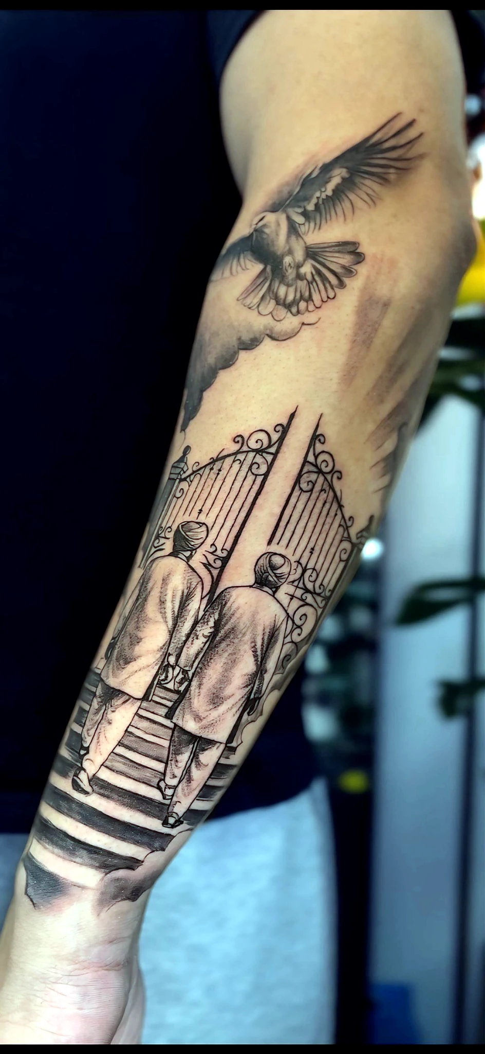 Black and grey gate and bird forearm tattoo by Rav Singh at Inkology