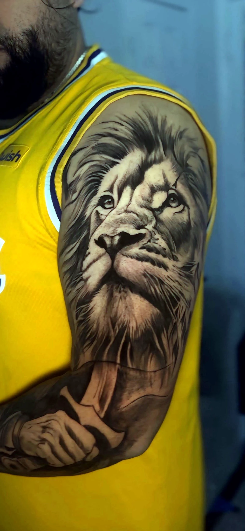 Black and grey realism lion in a yellow jersey by Rav Singh at Inkology