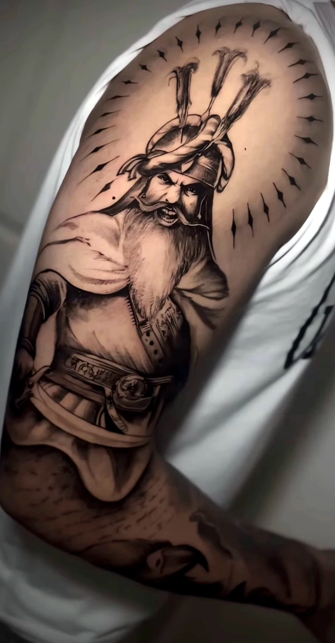 Black and grey realism warrior on the upper arm by Rav Singh at Inkology