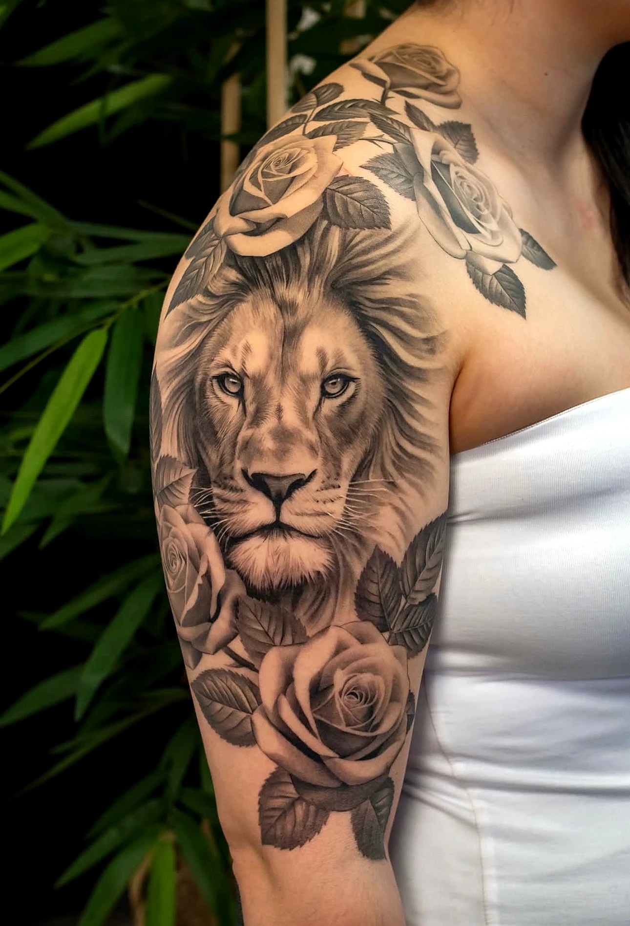 Black and grey realism lion and roses on the shoulder by Rav Singh at Inkology