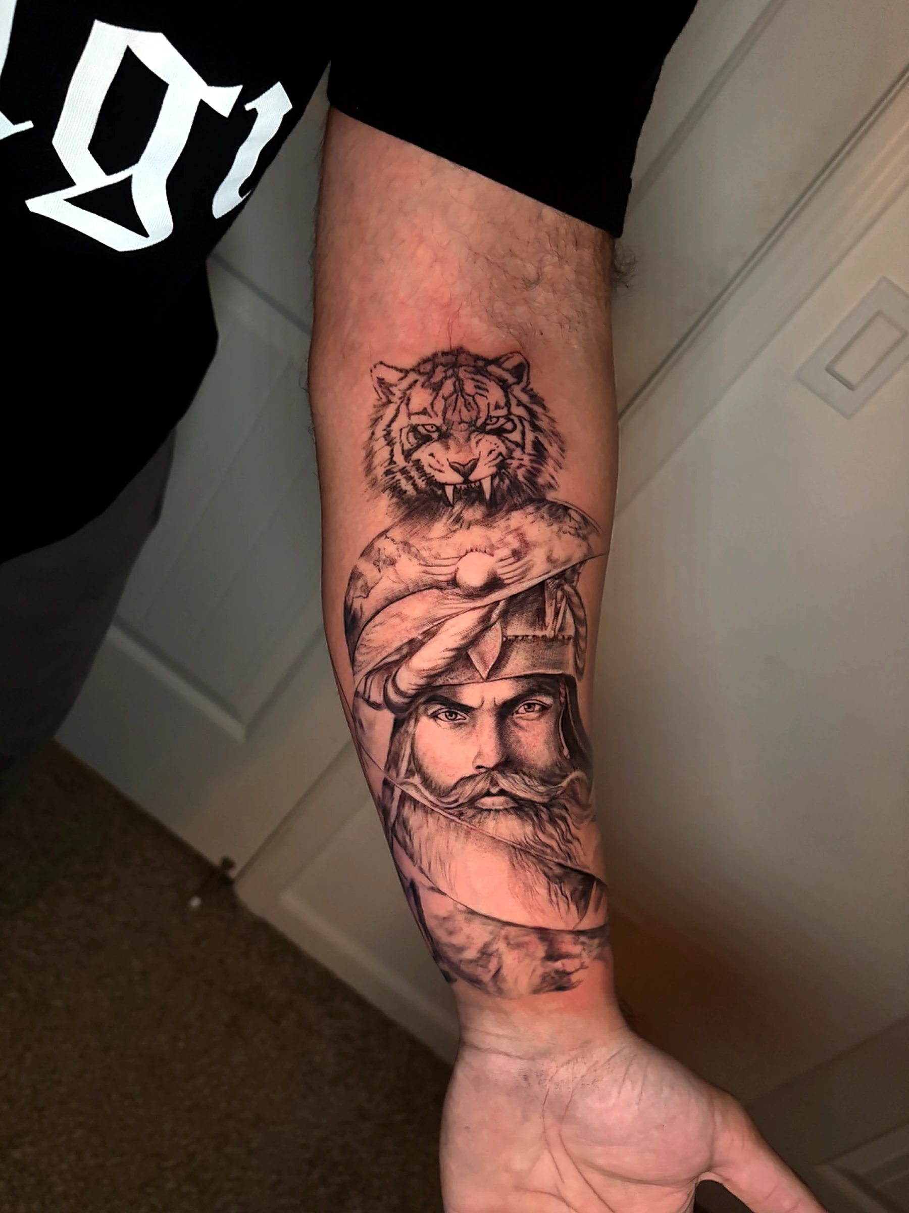 Black and grey realism tiger and warrior on the forearm by Rav Singh at Inkology